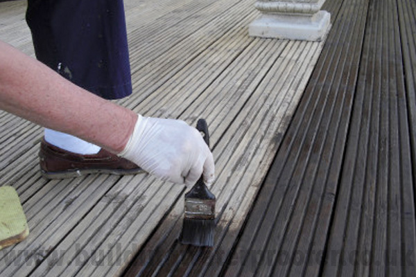 applying decking stain with brush
